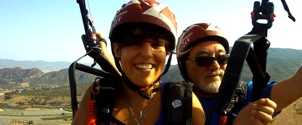 Piloto biplaza con pasajera sonriendo